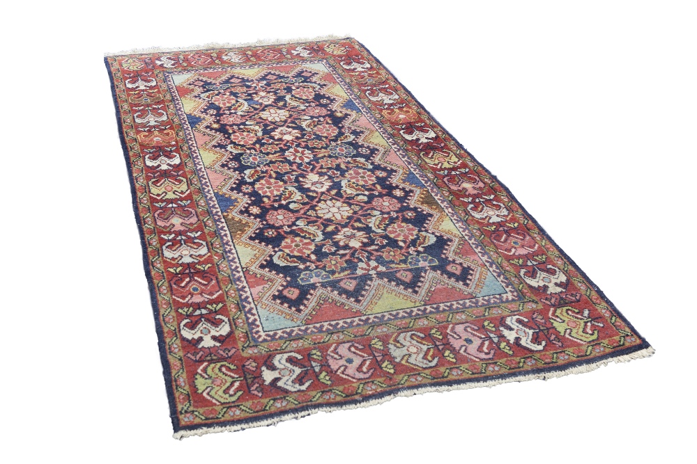 EASTERN RUG, with multi colour heratic floral design on a midnight blue field with zig zag