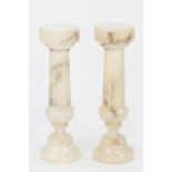 PAIR OF CARVED AND TURNED ALABASTER PEDESTALS, each with a circular top above a part fluted colum