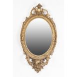 VICTORIAN GILT GESSO GIRANDOLE, the oval plate within a moulded frame with pierced scroll cresting