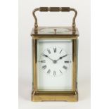 LATE NINETEENTH/ EARLY TWENTIETH CENTURY GILT BRASS REPEATING CARRIAGE CLOCK, the white enamelled