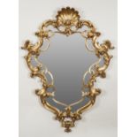 MODERN ROCOCO STYLE GILT FLANKED WALL MIRROR, the shaped plate in an ornate scrollwork frame with