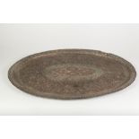 MIDDLE EASTERN PIERCED AND EMBOSSED COPPER LARGE TRAY, of oval form, intricately worked with