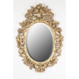 VICTORIAN CARVED GILTWOOD WALL MIRROR, the bevel edged oval plate within a pierced frame carved in