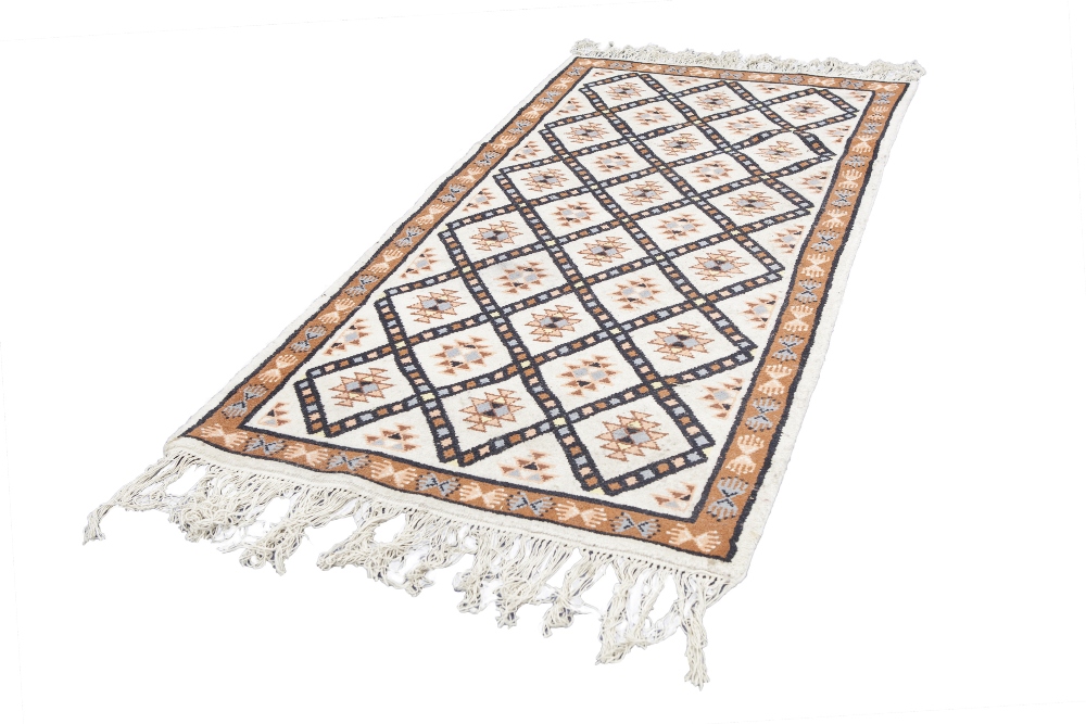 EASTERN RUG, decorated with rectangular guls within a trellis pattern on an off white field, the