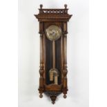 LATE NINETEENTH CENTURY STAINED AND CARVED WALNUT CASED VIENNA WALL CLOCK IN THE ART NOUVEAU