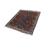 EASTERN TRIBAL RUG, with triple pole medallion in midnight blue on a crimson and stylized bird and