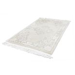 LARGE WASHED CHINESE EMBOSSED RUG, with floral centre medallion with mon and floral spandrels, on