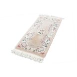 WASHED CHINESE 'KAYARN' SUPER QUALITY, ALL WOOL, EMBOSSED RUG, with three floral motifs on a pink