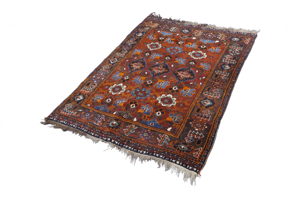 SHIRAZ TRIBAL RUG, with an all-over design of large flowers on a crimson field, broad border with