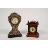 AN EDWARDIAN BLACK JAPANNED BALLOON SHAPED MANTEL CLOCK, faced with applied stamped silver mounted