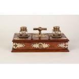 VICTORIAN STYLE BRASS MOUNTED MAHOGANY DESK STAND, of oblong from, surmounted by a pair of square