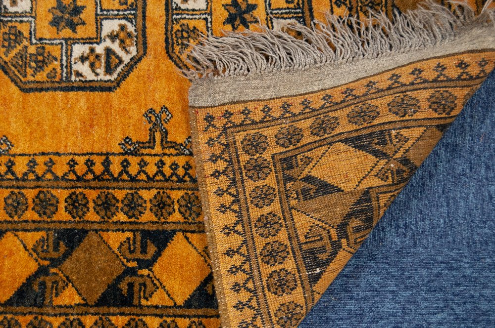 TURKOMAN AFGHAN RUG with two rows of five octagonal guls on an old gold ground, patterned - Image 2 of 2