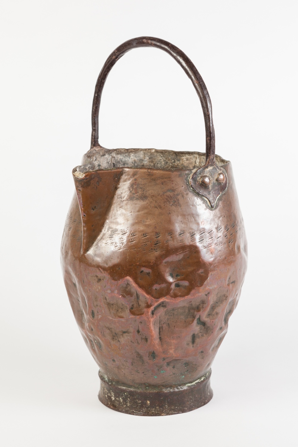 AN ANTIQUE COPPER JUG, bellied form with pinched spout, hammered band marking, riveted overhead