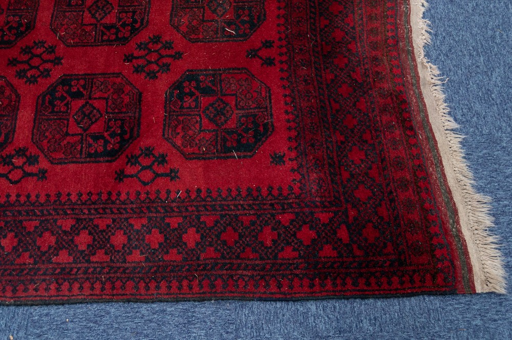 TURKOMAN AFGHAN RUG with two rows of four black stencilled octagonal guls on a crimson field, - Image 3 of 3