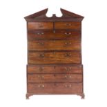 EARLY NINETEENTH CENTURY FIGURED MAHOGANY SECRETAIRE CHEST ON CHEST, the broken architectural