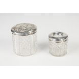 EDWARDIAN CUT GLASS CYLINDRICAL TOILET JAR with silver pull-off lid, repousse with two putti