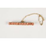 VICTORIAN GOLD (unmarked) BAR BROOCH, set with ten pink corals, and the safety chain, 2.6gms