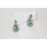 A PAIR OF 18ct WHITE GOLD, EMERALD AND DIAMOND TEAR SHAPED DROP EARRINGS, each collet set with a