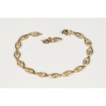 15ct GOLD BRACELET of pointed oval and flower head pattern links, 7 1/4" (18.4cm) long, (snapped), 6