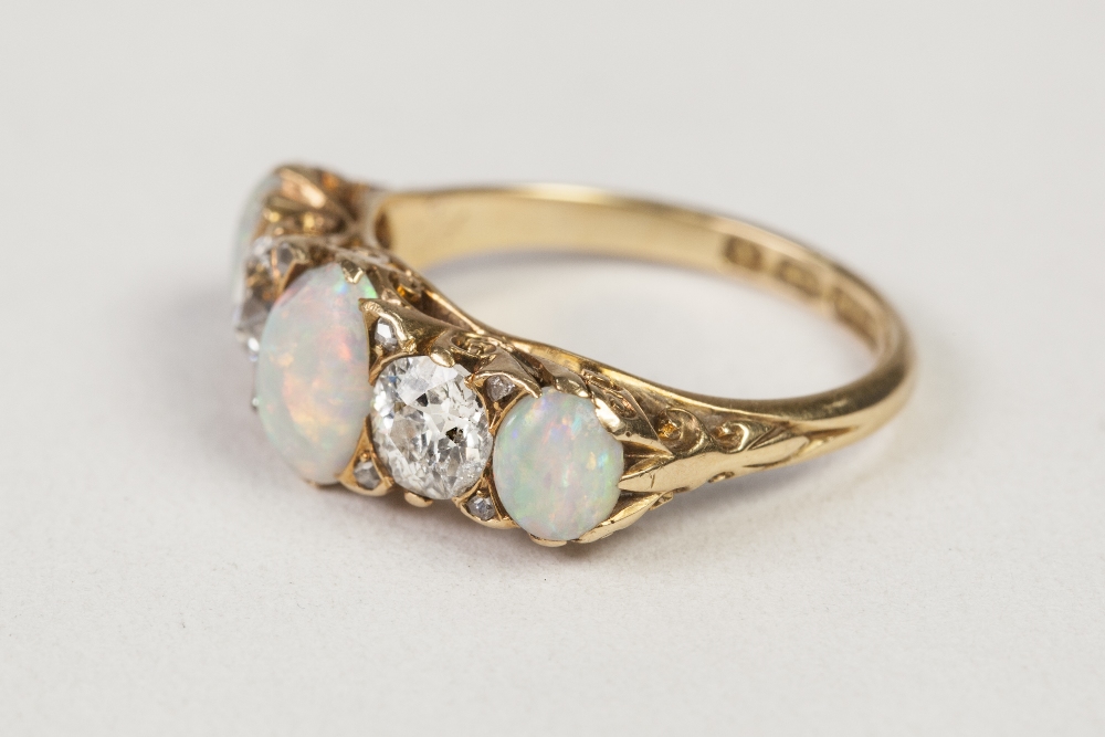 VICTORIAN 18ct GOLD, DIAMOND AND OPAL RING, with a carved setting of three oval opals, two round old - Image 2 of 2