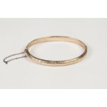 EDWARDIAN 9ct GOLD NARROW HINGE OPENING HOLLOW BANGLE, with floral engraved top, Birmingham 1901,