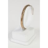 9ct GOLD HOLLOW, HINGE OPENING BANGLE with foliate engraved top, 8.4 gms