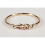 9ct GOLD HOLLOW, HINGE OPENING BANGLE, with 'loose knot' pattern top, 12.3gms