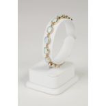 9ct GOLD AND OPAL BRACELET, having fourteen collet set oval opal links, 11.7gms