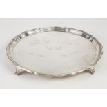 GEORGIAN STYLE SILVER PRESENTATION CIRCULAR SALVER with engraved signatures and raised on four tab