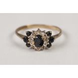 9ct GOLD, SAPPHIRE AND DIAMOND RING, set with a centre oval sapphire and surround of ten tiny