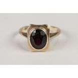 9ct GOLD RING, collet set with an oval garnet, 3.7gms, ring size P/Q