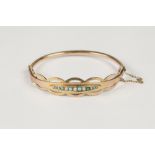 EDWARDIAN 9ct GOLD HINGE OPENING BANGLE, the top in the form of seven graduating oval rings