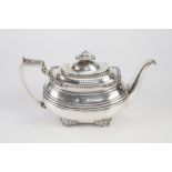 GEO IV ROUNDED OBLONG SILVER TEA POT with applied case decoration raised on four tab feet, the lid