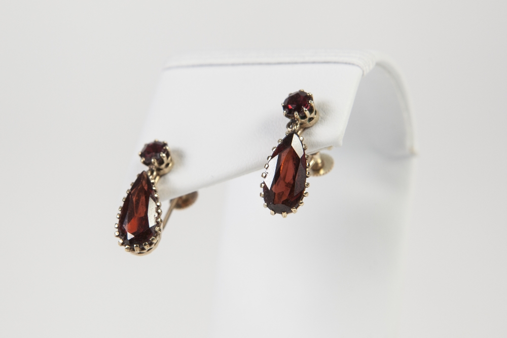 A PAIR OF 9ct GOLD AND GARNET EARRINGS, each set with a small round garnet and tear shaped garnet