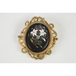 BLACK AND FLORAL OVAL PIETRA DURA BROOCH, in pinchbeck frame, with surround of two coiling serpents,