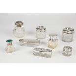 EIGHT VARIOUS LATE 19TH CENTURY AND LATER CUT GLASS AND OTHER TOILET BOTTLES WITH SILVER LIDS to