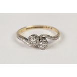 18ct GOLD AND PLATINUM CROSS-OVER RING set with two small diamonds, approximately 0.20 ct in