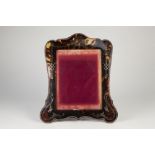 AN EDWARDIAN SILVER MOUNTED AND PIQUE WORK TORTOISESHELL easel support photograph frame, the