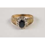 TEXTURED 18ct GOLD, SAPPHIRE AND DIAMOND CLUSTER RING, set with an oval sapphire and surround of
