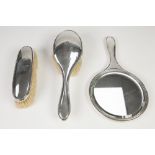 AN EARLY 20TH CENTURY SILVER THREE PIECE DRESSING TABLE OF HAND MIRROR, hair brush and clothes