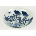 A CHINESE CHING DYNASTY PORCELAIN SHALLOW DISH, painted in underglaze blue with two horses beneath a