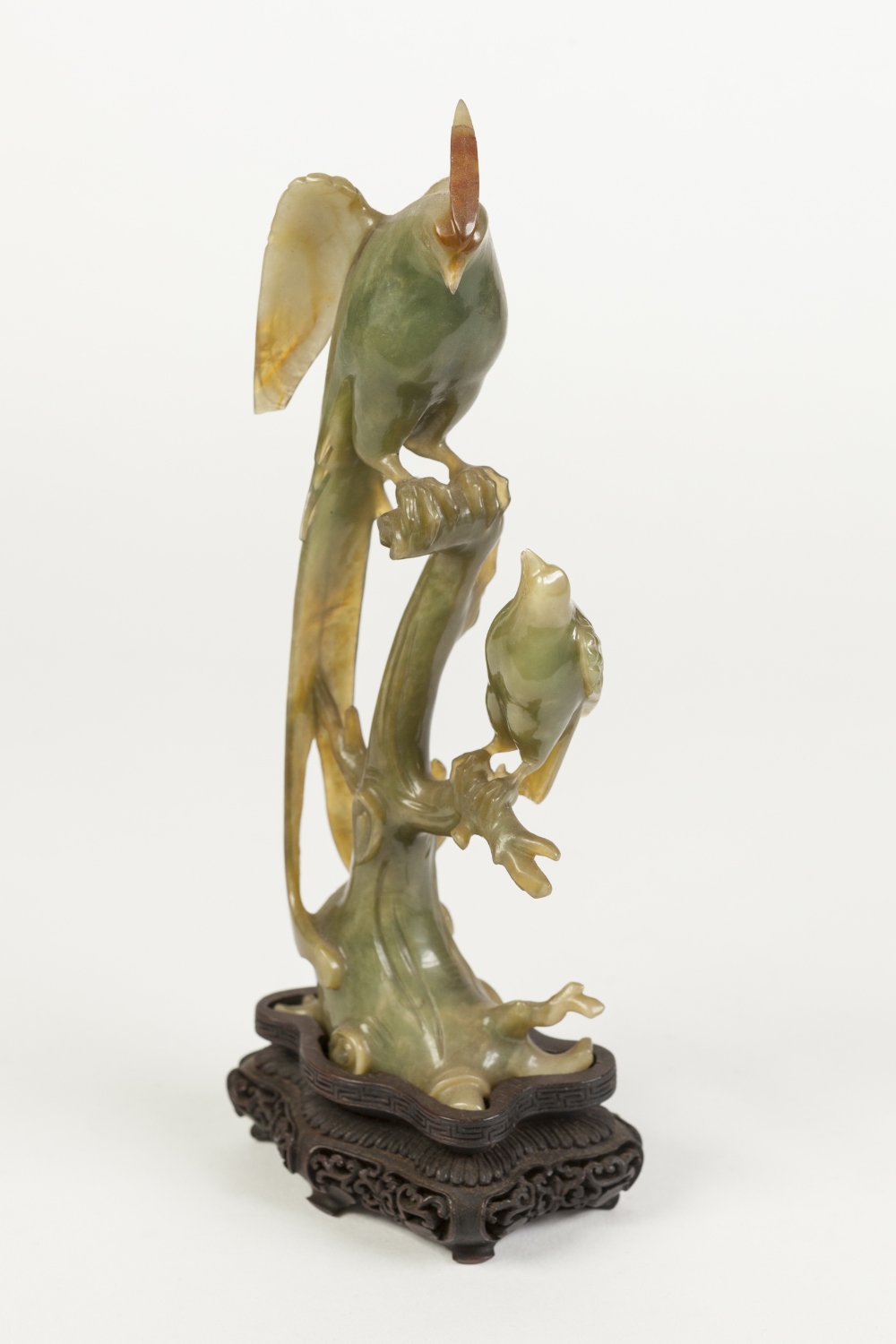 LATE NINETEENTH/EARLY TWENTIETH CHINESE CARVED GREEN HARDSTONE MODEL OF AN EXOTIC BIRD, perched upon