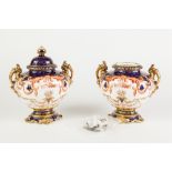 PAIR OF ROYAL CROWN DERBY PORCELAIN TWO HANDLED PEDESTAL URNS AND COVERS, each of oval form with