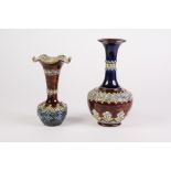 TWO DOULTON LAMBETH MOULDED POTTERY GLOBE AND SHAFT VASES, each with flared rim, one decorated