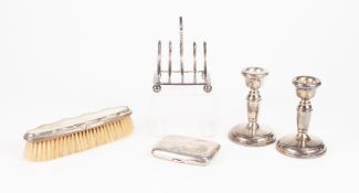 A PAIR OF WEIGHTED SILVER DWARF CANDLESTICKS, Birmingham 1990, a silver five division TOAST RACK,