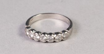 WHITE METAL RING COLLET SET WITH A ROW OF SEVEN SMALL DIAMONDS GRADUATING FROM THE CENTRE, 3.6