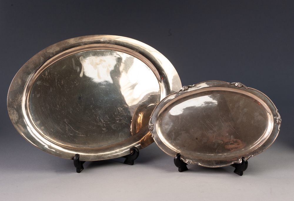 TWO FOREIGN SILVER COLOURED METAL OVAL SERVING DISHES, comprising: a plain example, with retailers