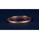 LATE VICTORIAN 9ct GOLD HOLLOW BANGLE, hinge opening with foliate scroll engraved top, Birmingham