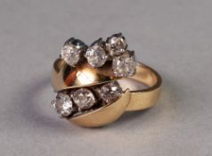 YELLOW AND WHITE GOLD COLOURED METAL FANCY CROSS OVER RING, set with seven various old cut diamonds,