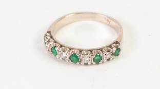 AN 18ct WHITE GOLD TINY DIAMOND AND EMERALD SET HALF HOOP RING, 3.7gms gross